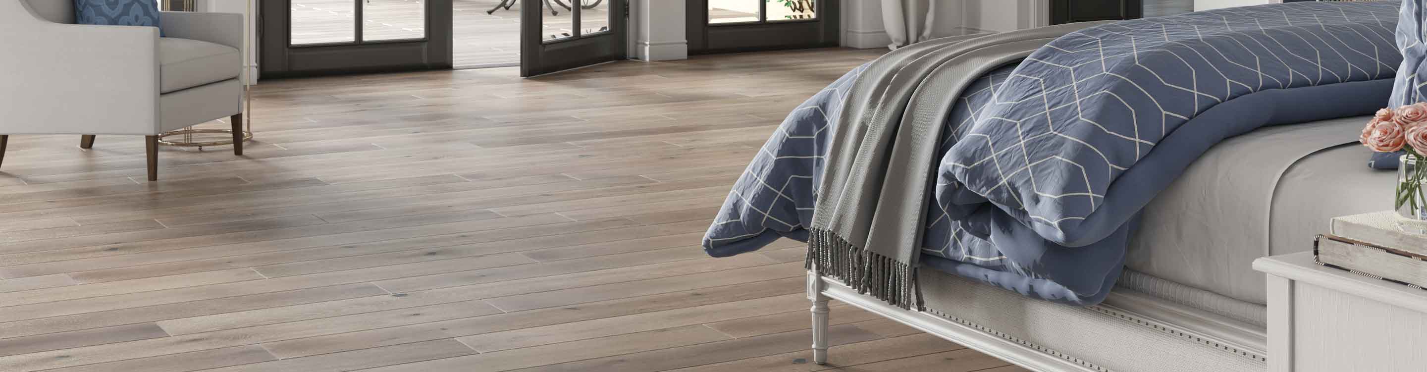 dark hardwood flooring in contemporary bedroom with blue bedspread, fireplace and double french doors