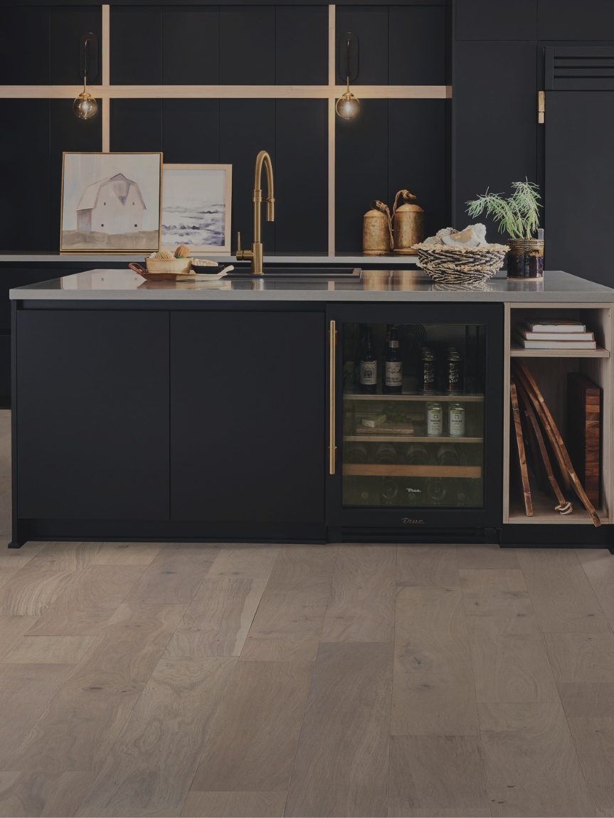 hardwood flooring in a modern kitchen with navy blue cabinetry and gold accents